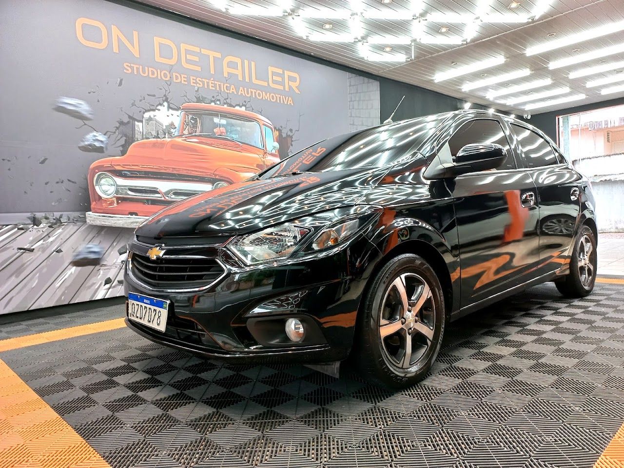 Carro preto com a pintura vitrificada brilhando sob o LED